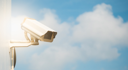 CCTV camera in security system in urban city with sky background in security concept,Soft focus with sun lightの写真素材