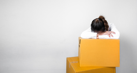 Woman sleeping on the box after moving home and moving the boxの写真素材