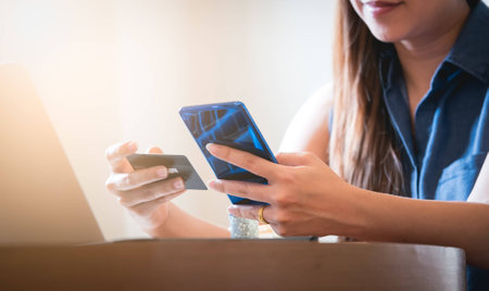 Women are entering a credit card number via mobile for online financial transactions, online ordering. Under the idea of the Internet of thing that can make financial transactions anytime, anywhereの写真素材