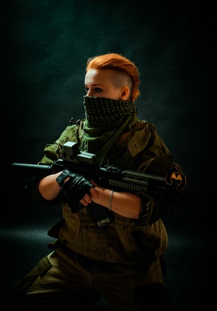 Young woman with red hair with a bandage on his face, hold machine gun on her hands in darck room....