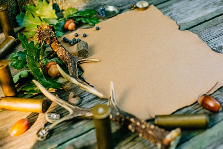 Closeup vintage sheet of paper with hunting equipment from left side on old wood boardの写真素材