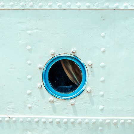 Round porthole on white board of ship.の写真素材