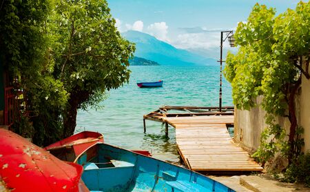 North macedonia. Ohrid. Old boats on shore beside wooden platform in lake.の写真素材