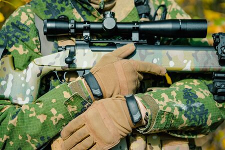 Closeup body of man in uniform with sniper rifle. Side view.の写真素材