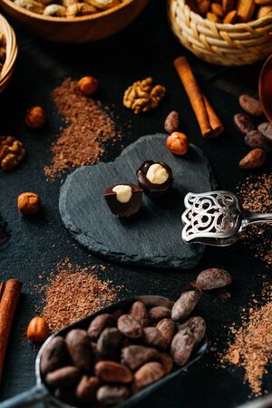 Cut handmade chocolate candy with haselnut on blackstone stand in heart shape. Chocolate candies...