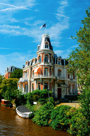 Canal in Amsterdam with boats and beautiful historic houseの写真素材