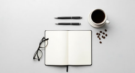 Top view of coffee cup, eyeglasses, coffee beans and notebook on white backgroundの素材