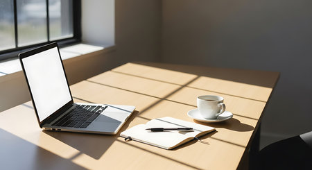 Laptop with blank screen and coffee cup on wooden table in officeの素材