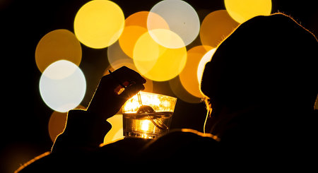 Man with a glass of alcoholic drink on a background of bokehの素材