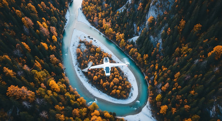 Aerial view of airplane flying over mountain river in autumn forest.の素材