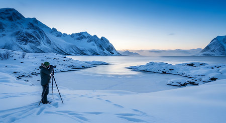 Photographer taking picture of snowy landscape at Lofoten islands, Norwayの素材