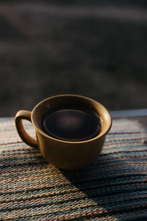 mug of coffee, tea on the background of home garden and sunsetの写真素材