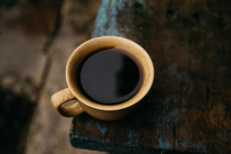 a cup of coffee stands on the table in gloomy and rainy weather. a cup of coffee in rainy weatherの写真素材