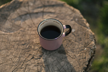 Cup of coffee on a wooden stump in the garden. Selective focus.の写真素材