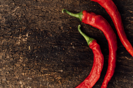Red hot chili peppers on wooden background. Top view. Copy space.