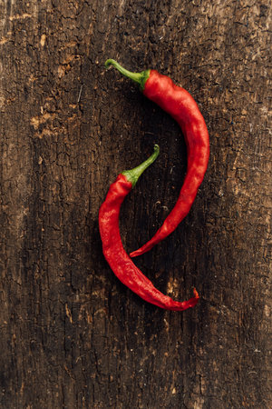 Red hot chili peppers on a dark wooden background. Top view.