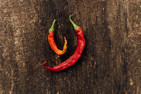 Red and yellow hot chili peppers on rustic wooden background, top viewの写真素材