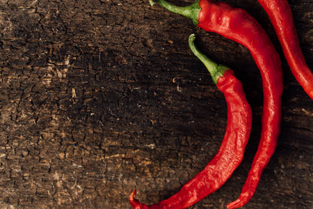 Red hot chili peppers on rustic wooden background, top view.の写真素材