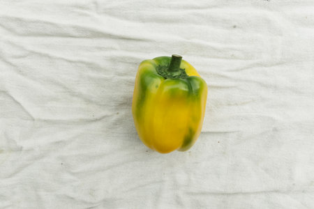 Yellow bell pepper on white fabric background. Top view. Close up.の写真素材