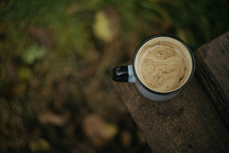 Cup of coffee on a wooden table in the autumn forest.の写真素材