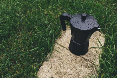 Coffee maker on the grass in the park. Toned.の写真素材