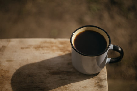 Coffee cup on a wooden table in the morning light.の写真素材