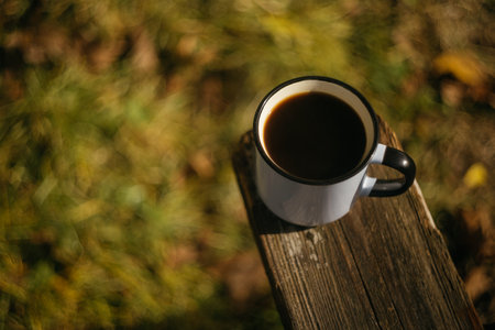 Cup of coffee on a wooden table in the autumn forest.の写真素材