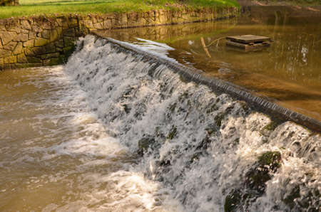 Small stream cascading over a weir, Pruhonice castle park, Czech republicのeditorial素材