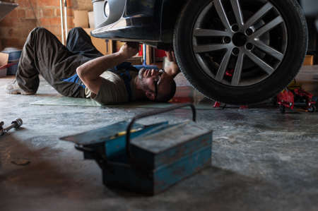 Mechanic fixing a car at homeの写真素材