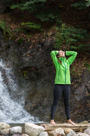 Woman enjoying near a waterfallの写真素材
