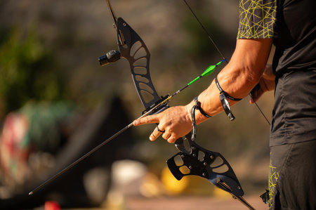 A man is holding a bow and arrow, pointing it at a target. Concept of focus and determination, as...