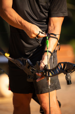 A man is holding a bow and arrow, preparing to shoot. Concept of focus and determination as the man...