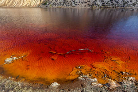 Red artificial lake and hills as a result of mining and production of copperの写真素材
