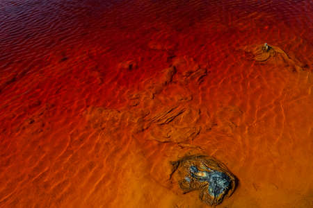 Red artificial lake and hills as a result of mining and production of copperの写真素材