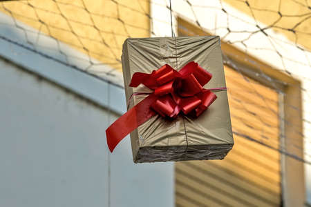 Gift boxes that hang suspended on wires and networks. Street decorations before Christmas, New Year...