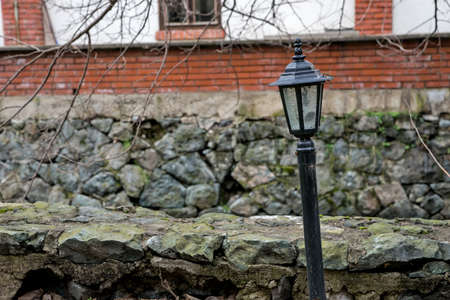 Crooked street lamp in front of a brick buildingの写真素材