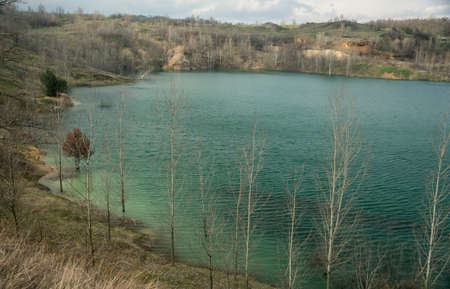 Lake shore with blue and green water over an old sunken mine silica sand with a layered coastの写真素材