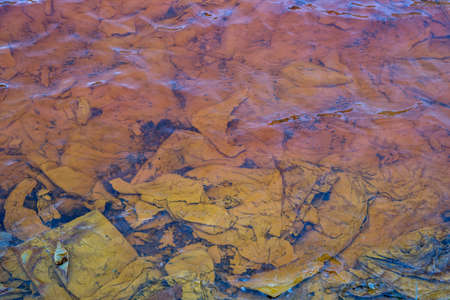 Red artificial lake and hills as a result of mining and production of copper