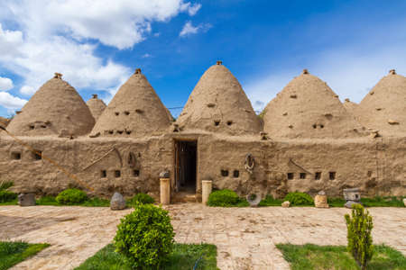 Photo is taken in Harran, Sanliurfa Turkey. This is the photo of the typical Harran house. Houses is made of mudbrick. Door and small windows can be seen too. Conic shaped and mudbrick and conic roofs are special to Harran area. Some special tool are hangのeditorial素材