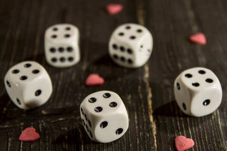 on the old wooden table are dice with heartsの写真素材