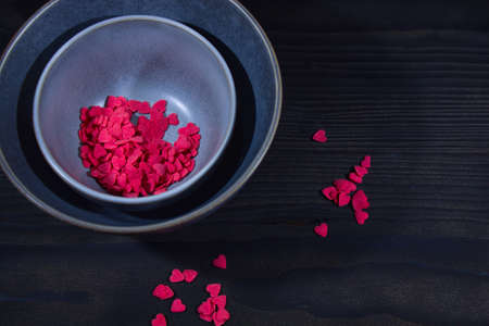 Valentines day on a black background with scattered heartsの写真素材