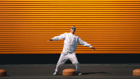 Portrait of a young guy walking around the city in a white suit and sunglassesの写真素材
