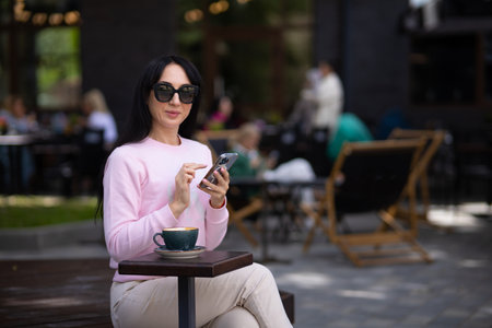 Portrait pretty trendy young brunette woman in stylish clothing with vintage cup in cafe. Elegant cute girl fashion model enjoys coffee break indoors. Morning for caffeine lovers.の写真素材