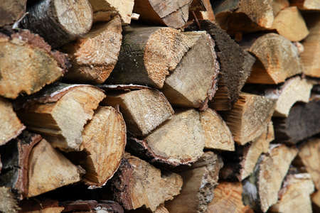 Dry birch firewood stacked in a neat woodpile. A supply of wood for kindling the fireplace. wooden texture.の写真素材
