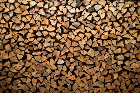 Dry birch firewood stacked in a neat woodpile. A supply of wood for kindling the fireplace. wooden texture.の写真素材