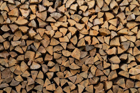 Dry birch firewood stacked in a neat woodpile. A supply of wood for kindling the fireplace. wooden texture.の写真素材
