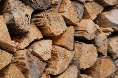 Dry birch firewood stacked in a neat woodpile. A supply of wood for kindling the fireplace. wooden texture.の写真素材