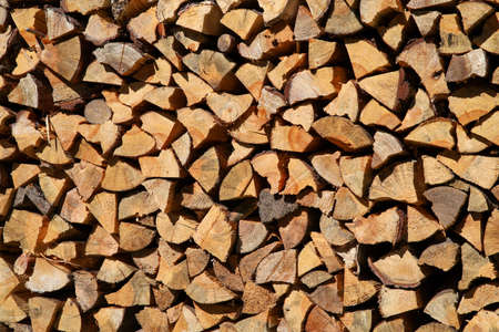 Dry birch firewood stacked in a neat woodpile. A supply of wood for kindling the fireplace. wooden texture.の写真素材