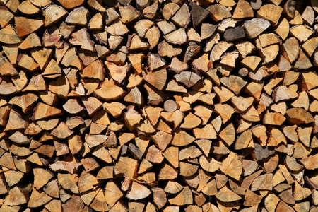 Dry birch firewood stacked in a neat woodpile. A supply of wood for kindling the fireplace. wooden texture.の写真素材