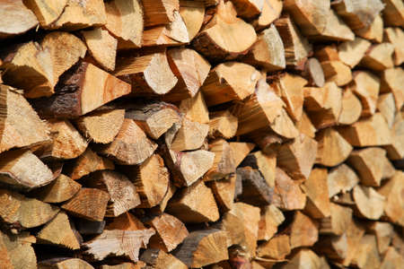 Dry birch firewood stacked in a neat woodpile. A supply of wood for kindling the fireplace. wooden texture.の写真素材
